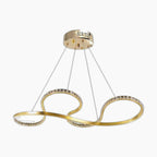 Ornate modern chandelier with gold drop pendants, crystal accents, and intertwined LED rings.