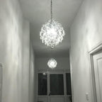 Two Maison Ornate Crystal Ball Chandeliers with triple drop shades, emitting bright white light.