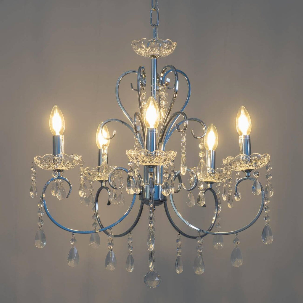 Five-light silver baroque chandelier with clear crystal accents and teardrop crystals on each arm.