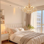 Maison Ornate Elegant Crystal Chandelier with Gold Tassels, sparkling in natural sunlight overhead.
