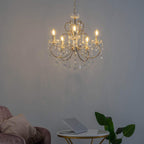 Baroque crystal chandelier with gold tassels and ornate metal arms by Maison Ornate, elegantly suspended.