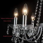 Close-up of Maison Ornate chandelier with chrome arms, crystal pendants, and candle-shaped bulbs.