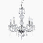 Ornate vintage crystal chandelier with five candle bulbs, chrome finish, glass arms, and acrylic pendants.