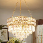 Gold stainless steel chandelier with tiered K9 crystal prisms and chains, creating a warm, luxurious glow.