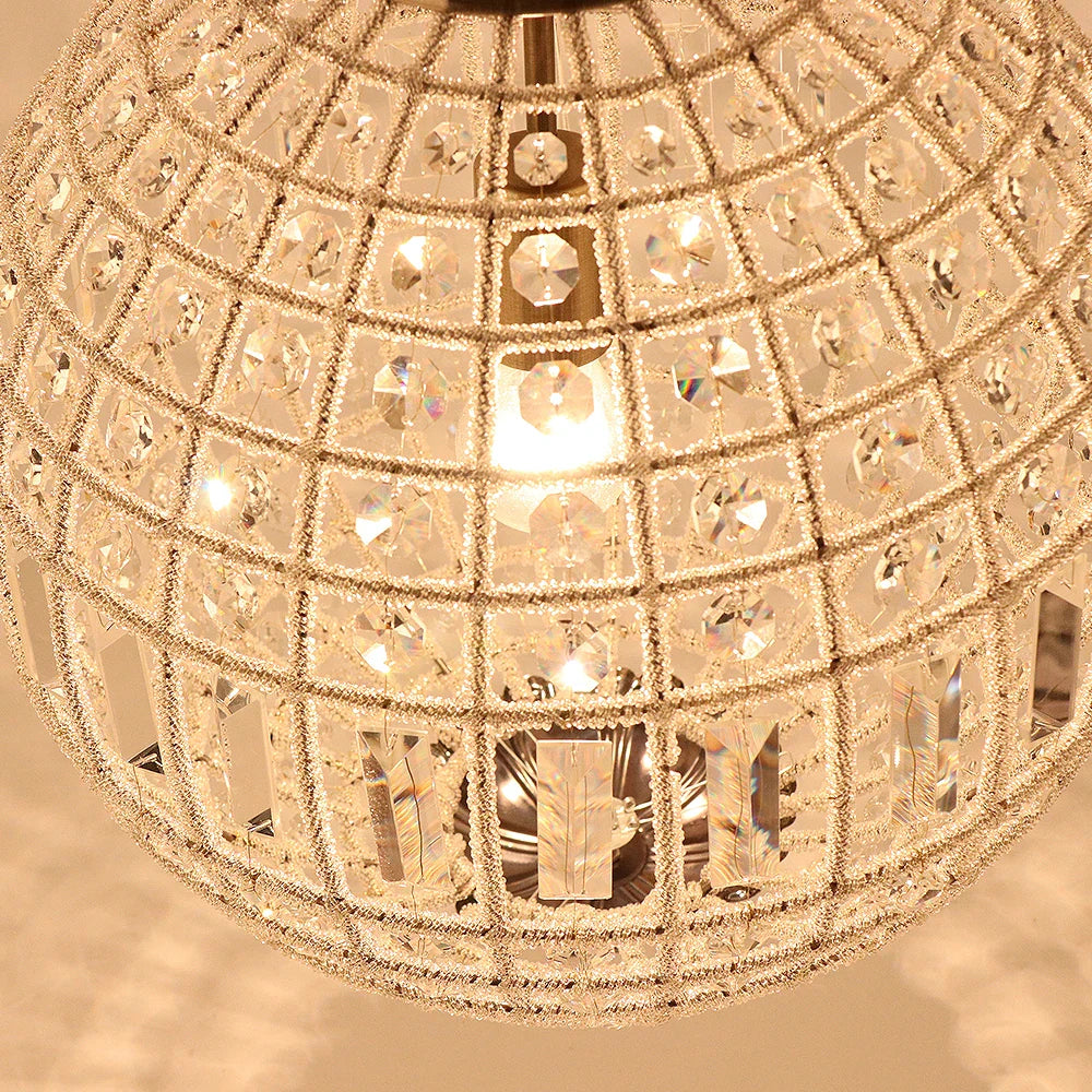 Close-up of Maison Ornate's bronze crystal ball chandelier, metallic frame, sparkling faceted K9 crystals.