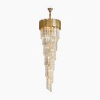 Spiral LED chandelier with gold and clear glass prisms, modern luxury stairway lighting.