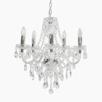 Modern crystal acrylic and metal chandelier with five candle bulbs, chrome accents, and hanging crystals.