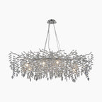 Modern crystal chandelier with chrome branches, LED bulbs, and hanging crystal droplets for elegance.