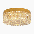 Modern gold chandelier with integrated LED and clear crystal prisms, emitting a warm elegant glow.