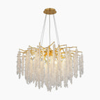 Elegant gold-toned chandelier with cascading clear crystals and LED lighting, suspended from round mount.