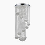 Round chrome chandelier with cascading crystal strands and clustered spheres at varied heights, modern design.