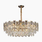 Modern chandelier with tiered clear glass prisms, gold metal base, and twisted adjustable suspension rod.