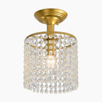 Modern glass and gold chandelier with a single bulb, surrounded by clear crystal bead cylinders.