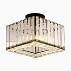 Square crystal glass LED chandelier with clear vertical panels and black base, radiating warm, modern elegance.
