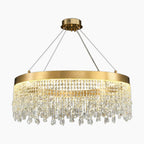 Modern crystal chandelier with gold ring, round pendants, and sparkling prisms suspended by four cables.