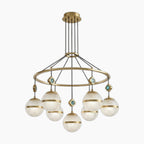 Seven textured glass globes hang from a gold circular frame with turquoise accents; modern chandelier.