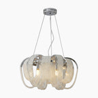 Curved chrome and crystal chandelier with LED tassels, exposed bulbs, and three suspension cables.