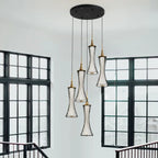Modern LED crystal chandelier with five hourglass lamps on a sleek black ceiling mount.