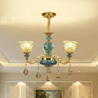 Baroque chandelier with three glass lamps, turquoise blue and gold accents, and crystal teardrops.