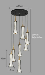 Modern LED chandelier with seven pendants, gold accents, black stripes, white hourglass shades. Adjustable length.