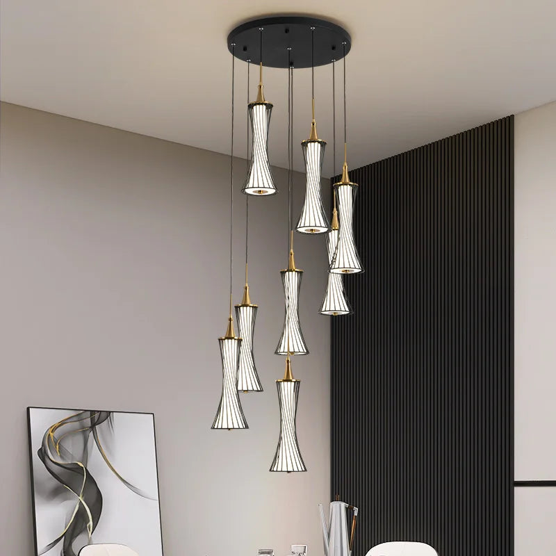 Eight hourglass-shaped crystal pendants hang at varied heights from a round black chandelier mount.