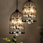Pair of Maison ornate Art Deco crystal chandeliers with black iron cages and sparkling crystals.