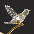 Close-up of Maison Ornate's Golden Crystal Chandelier with bird-shaped LED and gold branch.