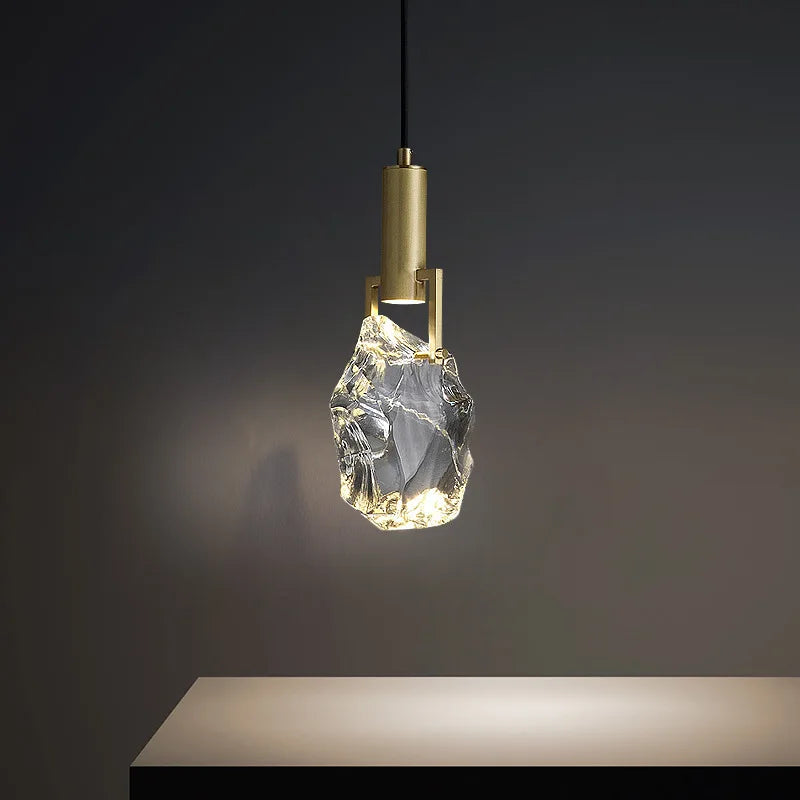 Modern minimalist chandelier with copper fixture and clear faceted crystal shade, elegant bedroom lighting.