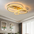 Three circular stainless steel chandelier rings edged in crystals, emitting a warm, modern glow.