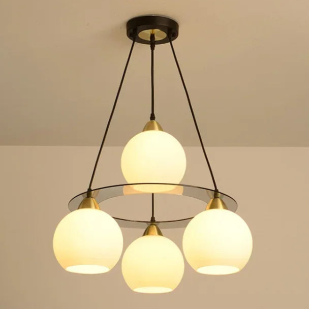 Three round crystal chandelier heads in a circular design, suspended by black rods, Art Deco-inspired.