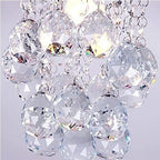 Close-up of crystal pendant chandelier with silver chains and tassels, shimmering with refracted light.
