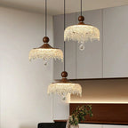 Three ornate French medieval-style crystal teardrop chandeliers with wooden tops and crystal beaded fringe.