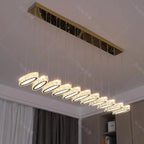 Modern gold-mounted chandelier with ten crystal-like LED pendants in sleek, elegant row.