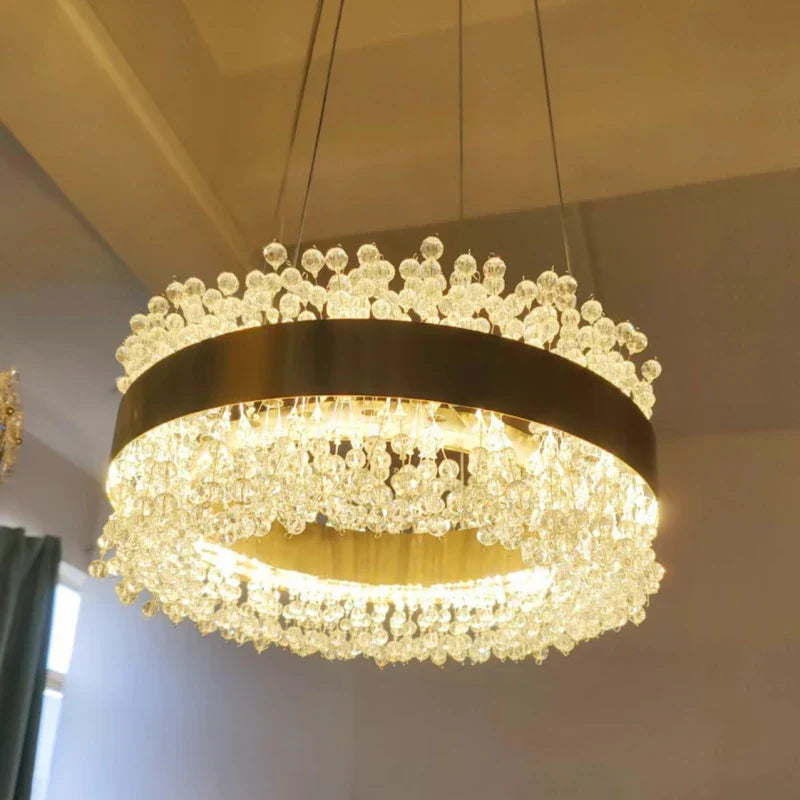Gold-frame modern LED chandelier with crystal droplets, adjustable height, and elegant luxurious lighting.