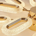 Close-up of an elegant gold-accented chandelier with textured glass shades and floral motif.
