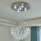Modern spherical chandelier in polished steel, with multiple hanging crystals and built-in LED lights.