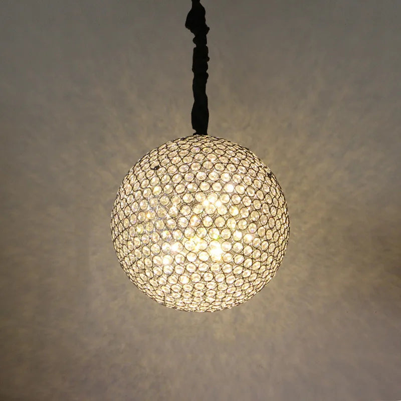 Maison Ornate Round Crystal Ball LED chandelier, suspended and emitting warm glow with intricate light patterns.