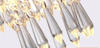 Close-up of the Art Deco chandelier with faceted teardrop glass and gold stainless frame sparkling.