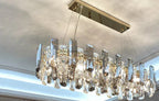 Modern crystal LED chandelier with gold base and faceted glass, creating sparkling, elegant illumination.