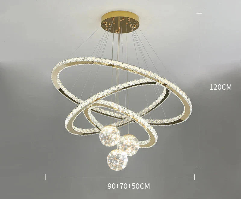 Three intertwined LED rings and four starry glass balls on a gold base chandelier.