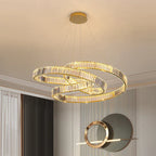 Three intertwined gold crystal rings form a minimalist LED chandelier, suspended by slender wires.
