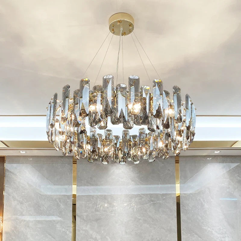 The Maison Ornate Modern Crystal LED Chandelier has clear prisms, gold accents, and circular design.