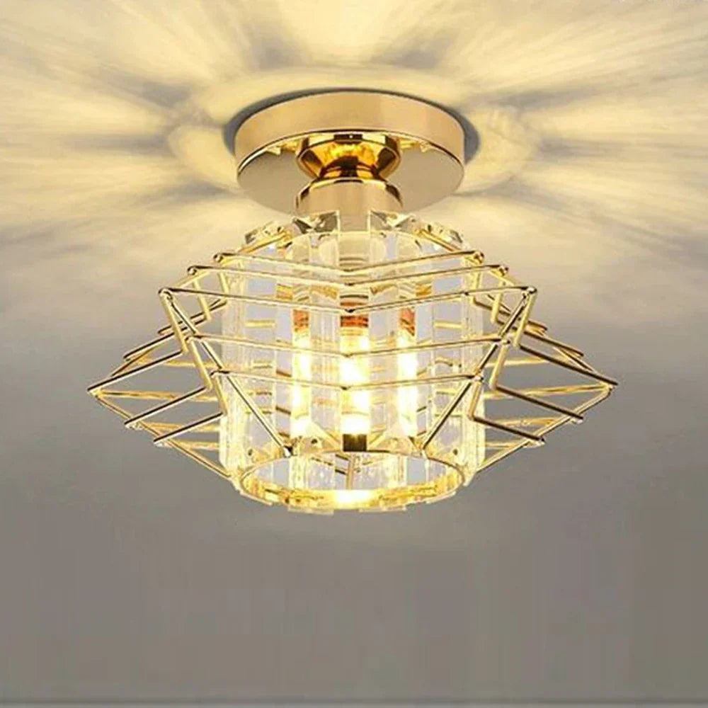 Modern industrial chandelier with gold geometric metal frame and crystal accents, casting decorative light.
