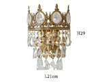 Ornate crystal ball chandelier with crown top, oval accents, and hanging prisms, 29x21 cm.