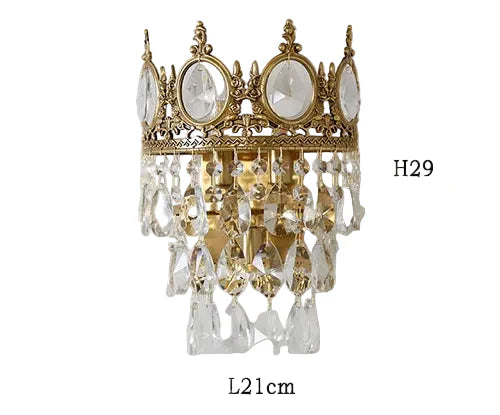Ornate crystal ball chandelier with crown top, oval accents, and hanging prisms, 29x21 cm.