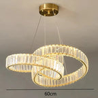 Two overlapping gold rings with clear crystals form a modern chandelier, thin wire suspension.