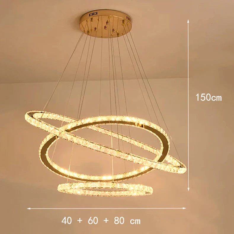 Gold-finished chandelier with three dimmable LED crystal rings, suspended by cables, modern design.