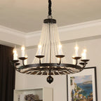 Elegant crystal chandelier with gold details, tassels, candle-style bulbs, and sparkling crystals.