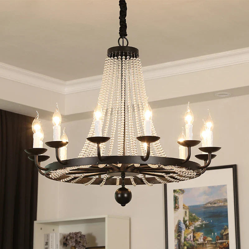 Elegant crystal chandelier with gold details, tassels, candle-style bulbs, and sparkling crystals.
