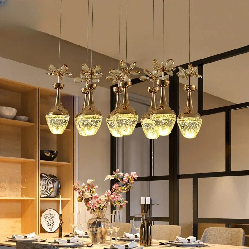 Set of six Maison ornate minimalist crystal LED pendant chandeliers, elegantly suspended in a row.